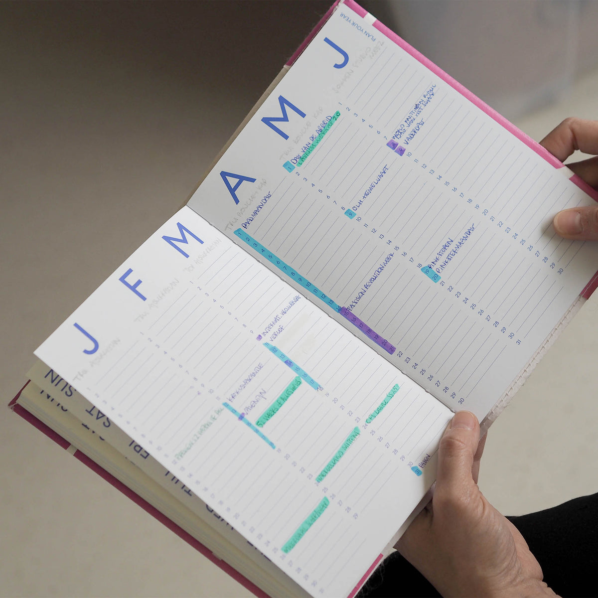 De Redopapers Agenda in gebruik: de agenda ligt open op het maandoverzicht waarbij kleur wordt gebruikt om maanddoelen aan te duiden